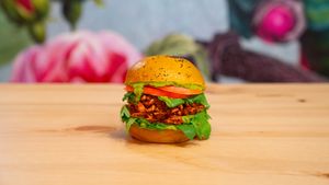 Tumeric bun with poppy seeds, guacamole, planted pulled BBQ, tomato, rocket salad at Green M'ama in Naples