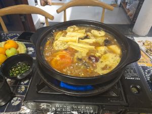 Cooking vegetables and tofu in the hotpot broth at Yún Shān Zhī Jùn 雲山之菌 in Dali