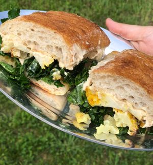 Vegan Breakfast & Lunch Sandwiches. Pictured here: Roasted Cauliflower, White Bean Hummus, Marinated Kale Sandwich on Ciabatta at Morning Sunshine Market in Ellenville