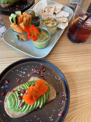 Vegane Aperoplatte mit zweierlei hausgemachtem Hummus, hausgemachter Oliventapenade und hausgemachtem Fladenbrot. Veganer Avocadotoast. Hausgemachter Ice Tea.  at Malou's Café & Diner in Lenzerheide