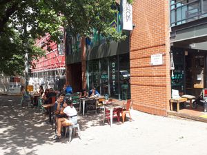 Outdoor sitting area under a tree at Sweet Bones Bakery Cafe in Scullin