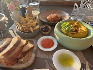 Sourdough, olives, riganada, chickpea stew, fresh potatoes (chips…!)  at Oia Gefsis in Oia