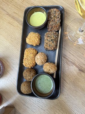 ‘Mix hug’: Olives stuffed with minced soy, ‘Mozzarelline’ - fermented cashew with quinoa breading, Spicy falafel, Tofish - marinated tofu with nori seaweed.  at Cagiada Milano in Milan