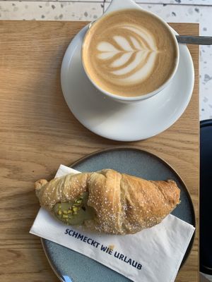 Pistachio cornetto and cappuccino w\ oat milk   at Grey Kaffee in Vienna
