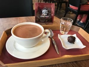 Big hot chocolate with a piece and water at Laurent Gerbaud Chocolatier in Brussels