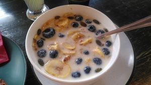 Granola bowl with almond drink, dried banana slices and blueberries at A Little Lost in Munich