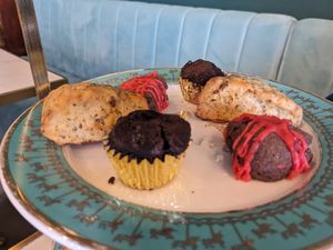 Middle tier of afternoon tea, savory scone and two chocolate desserts at Unicorniverse Bakery & Cafe in Round Rock