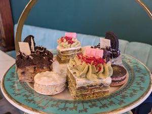 Top tier of afternoon tea, 2 cakes and 2 macaroons at Unicorniverse Bakery & Cafe in Round Rock