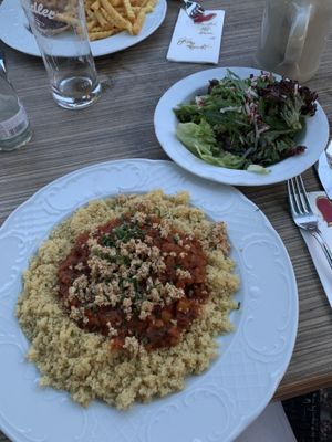Couscous with lentil bolognese and homemade vegan Parmesan, served with side salad    at Wirtshaus Zum Kaisermann in Kundl