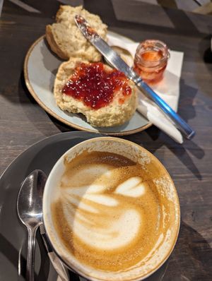 Oatmilk latte and delicious vegan scone with jam 😋 I love when scones are not sweet ❤️ at Tanifiki in Edinburgh