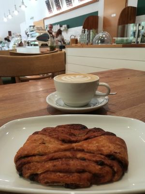 Cinnamon-chocolate roll with large oatmilk cappuccino at Ecocafe in Budapest