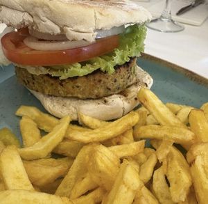Hamburguesa de quinoa con lechuga, tomate y cebolla. La receta original lleva huevo, pero si se lo quitas la haces vegana. Va acompañada de patatas fritas.  at Bom Jesus in Valenca