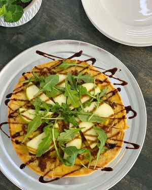 The Carm-O Flatbread - rosemary garlic olive oil, smoked gouda cheese, caramelized onions, granny smith apple, arugula and balsamic glaze.  at Vibrant Beat Cafe in Fort Myers