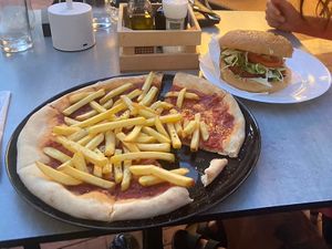 Vegan Burger with vegan meat patty, ayvar sauce and vegetables. Pizza with fries and without cheese. Both very good and fair price.  at Okrepčevalnica Barka in Piran