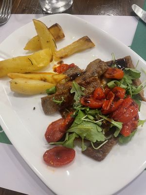 Tagliata di seitan, pomodorini rossi cotti a bassa temperatura, rucola e aceto balsamico (€14)  at La Puntarella Pazza in Rome