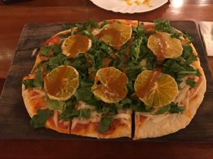 Vegan pizza with tangerines at La Hoja Verde in Tulum