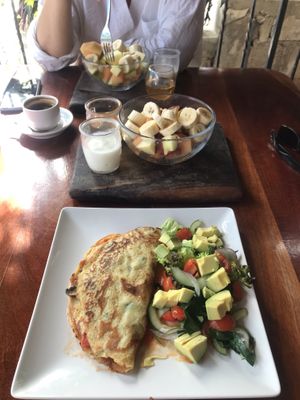 Chickpea and turmeric vegan omelette + fruit bowl with coconut yogurt & agave syrup. at La Hoja Verde in Tulum