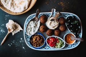 Mezze Platter is a dish with humus, black olives, mouhamarra, eggplant dip, falafel and a pita.  There is normally tzaziki, but for the vegan option you can ask to switch it.  at Yuni Yupoun  in Luang Prabang