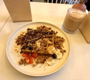Belgische Waffel mit Granola und Schoko-Karamell-Soße + Kaffee Latte  at Vegan Vibes in Berlin