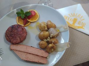 Opção de prato Burger e salsicha veganos. Acompanhamento escolhido batata a murro no forno (podia ter sido outro e até dois diferentes). at Taberna Belo in Mealhada