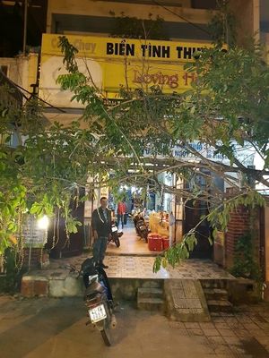 loving hut store front is covered by huge tree at Loving Hut - Bien Tinh Thuong in Da Nang