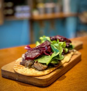 Flat bread with pickles beets, mushrooms mixed greens vegan mozzarella  at Java Blue Coffee and Market in Montgomery