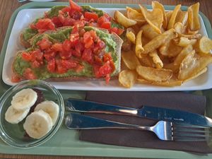 Avocado and tomatoes on bread with fries and fruit at Barmezzo - YellowSquare Firenze in Florence