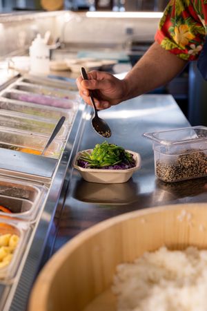Preparing a vegan bowl at Noa Poke Koukaki in Athens