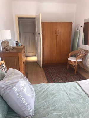 The light is shining through the glass in the front door.
Upper right, ironing board and useful mirror on wall. Plenty of space to put clothes etc. at Kettering B&B in Kettering