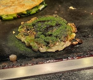 Vegetarian Okonomiyaki without egg. Mushroom and konjac inside. Sauce, aonori seaweed and mustard on top.   at Okonomiyaki Mizuno in Osaka