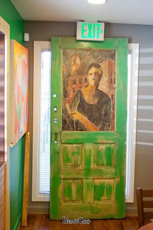 Green door, an art, leaning under an Exit sign at Mead's Green Door Cafe in Orange