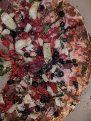 Pizza red sauce, beyond meat, vegan cheese, olives, spinach, artichokes, tomatoes, pineapple, peppers, mushroommmmmms at Leonardo's Pizza in Burlington