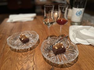 Schnapps and friandises (chocolate brownie with hazelnut and pear gel)  at Wolfs Junge in Hamburg