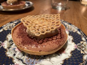 Dessert with chocolate mousse in a crispy shell, pear gel and walnut ice cream.  at Wolfs Junge in Hamburg