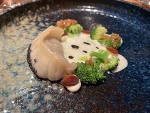 Dumpling with seitan and mushrooms, miso foam, soy sauce fermented garlic, vegan mayonnaise, herb oil and broccoli  at Wolfs Junge in Hamburg