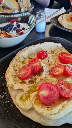 Breakfast "Tel Aviv": Pita with hummus and tomatoes and mango-yoghurt-bowl with coconut and berries at Cafebar Essen und Trinken in Straubing