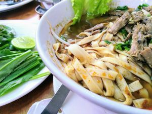 Noodle soup with mushroom 'steak' chunks & selection of fresh herbs at Mercy House in Phnom Penh