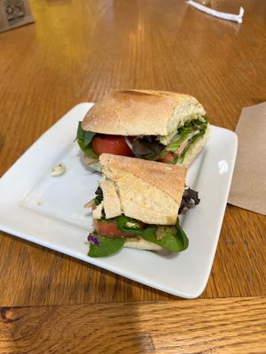 Breakfast sandwich, vegan baguette, tomato, spinach, mixed greens.  at Amélie's  in Charlotte