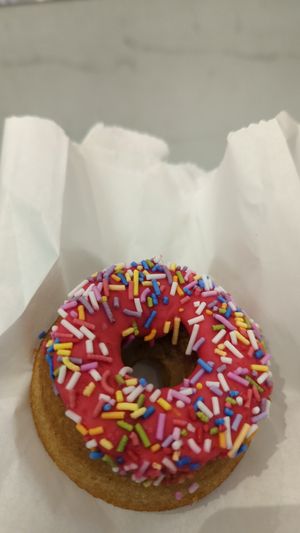 Donut with rainbow sprinkles at Kupfert & Kim - Financial District in Toronto