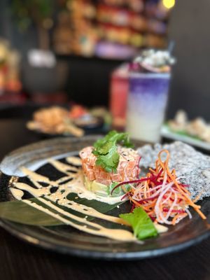 The SALMON MEETS AVO features our vegan „salmon“ sashimi tartare, avocado, our homemade cocktail sauce, a Vietnamese sesame rice cracker and fresh herbs. at IV in Berlin