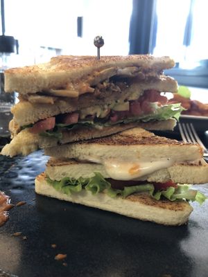 Club sandwich tofu affumicato, seitan, avocado, lattiga, pomodori e maionese veg  at Motus • Contemporary Bistrot in Grado