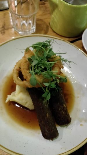 Seitan sausages, potato puree and onion rings at The Green Rocket Cafe in Bath