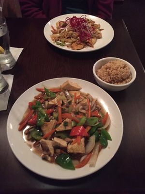 Plate closest to camera: Pad Ginger dinner entreé made with tofu, and brown rice on side.  at Cravin Thai in Hamburg