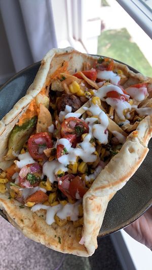 Pita wrap with grilled veggies (brussel sprouts, cauliflower, carrots), falafel, tomatoes, corn, pita crisps, red pepper hummus, and garlic dressing  at CAVA in Fredericksburg