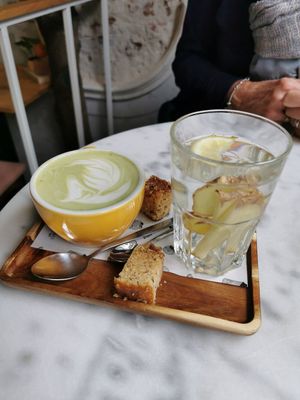 Matcha latte and fresh ginger tea with small pieces of vegan vanilla cake at The Happiness Café in Den Bosch