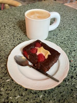Raspberry brownie and latte. at Korzenie Kuchnia Roślinna  in Szczecin