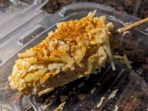 vegan elote—corn on the cob smothered in butter, sour cream, and shredded cheese, topped with tajín at La Rumba Restaurant Latino in Asheville