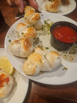 Garlic knots arrived in a pool of butter, slightly raw inside at Pasta Grill Mansfield in Hackettstown