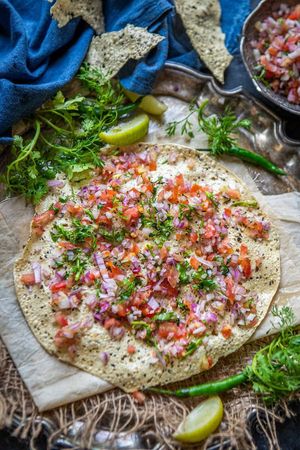 Masala papad is a vegan, gluten-free and nut-free Indian snack,a starter snack of crispy fried papad topped with a tangy, spiced masala filling of onions, tomatoes, herbs and spice at Daal Roti - La Casa De Comida India in Barcelona