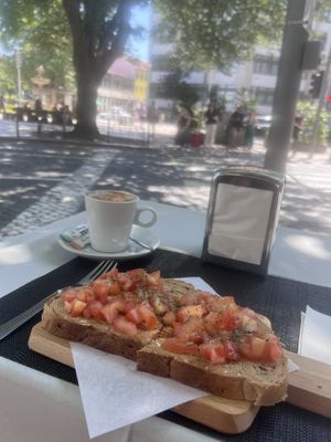Oatmilk cappuccino & tomato, basil, olive oil toast  at Metro da Trindade in Porto